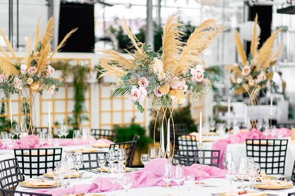 Hochzeitstisch mit Blumen, Kerzen und edlen Gläsern